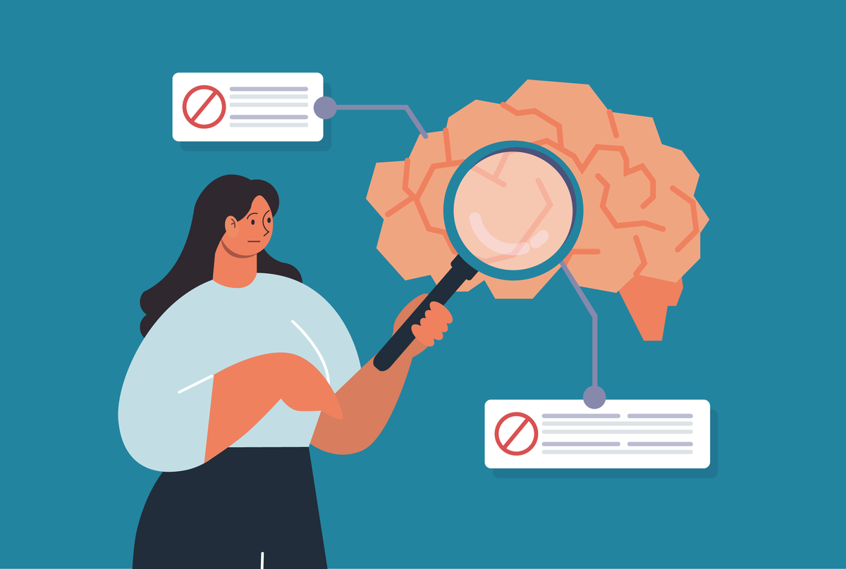 Na obrazku widoczna osoba z lupą skierowaną na grafikę mózgu.